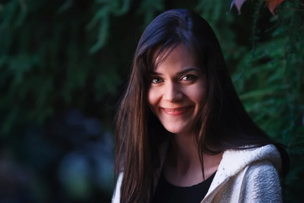 Mulher sorridente na floresta escura no crepúsculo — Fotografia de Stock