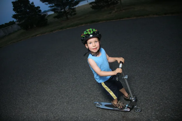 Kleine jongen paardrijden scooter buiten — Stockfoto