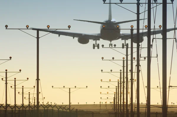 Vliegtuig over start-en landingsbaan — Stockfoto