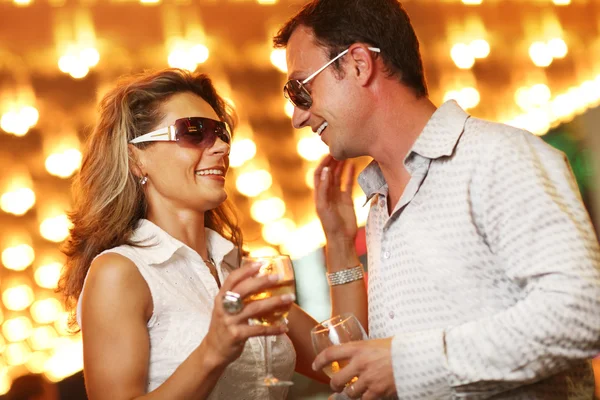 Volwassen paar genieten van het nachtleven met glazen van champagne — Stockfoto