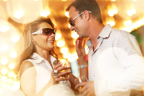 Volwassen paar genieten van het nachtleven met glazen van champagne — Stockfoto