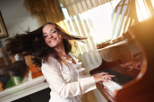 Jonge vrouw spelen piano — Stockfoto