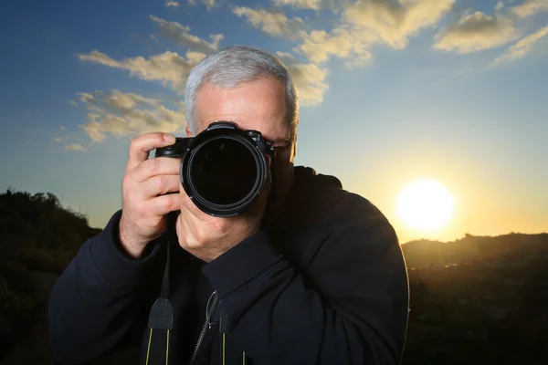Fotógrafo da natureza fotografando ao pôr do sol — Fotografia de Stock