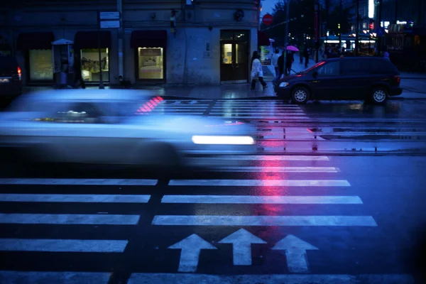 Auto přes přechod pro chodce v noci, rozmazaný pohyb. — Stock fotografie