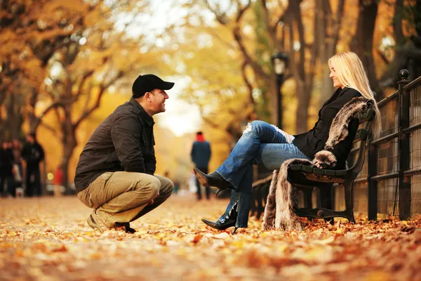 Man praten met hete blonde vrouw in herfst park. — Stockfoto