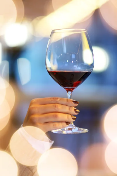 Female hand holding glass of red wine — Stock Photo, Image
