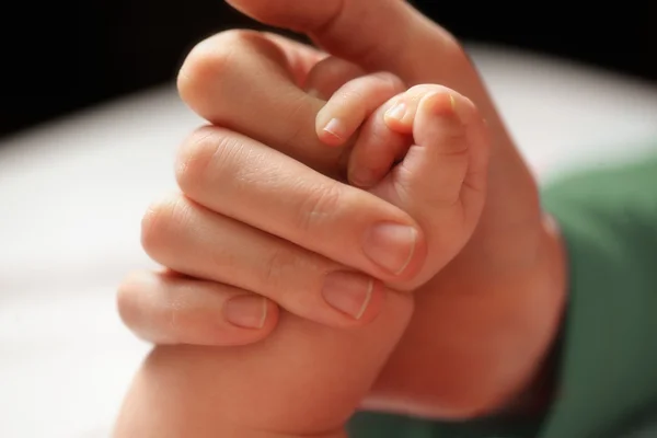 Baby hält die Hand der Mutter. — Stockfoto