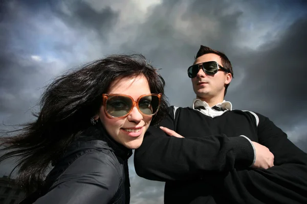 Cool pareja joven sobre el cielo nublado dramático — Foto de Stock