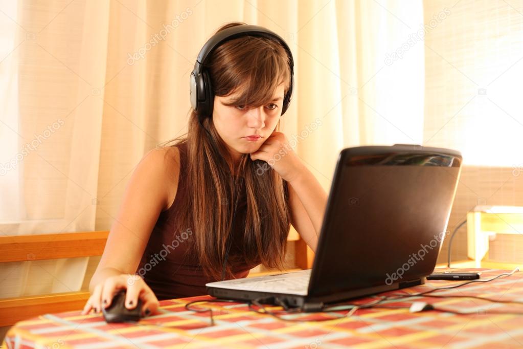 Teenage girl using laptop computer at home
