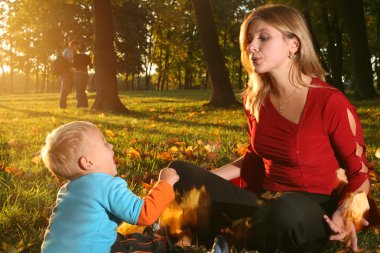 Oğlum bir sonbahar Park ile oynarken annesi.