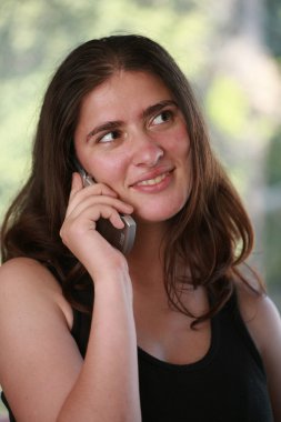 Genç bir kadın cep telefonuyla konuşuyor..