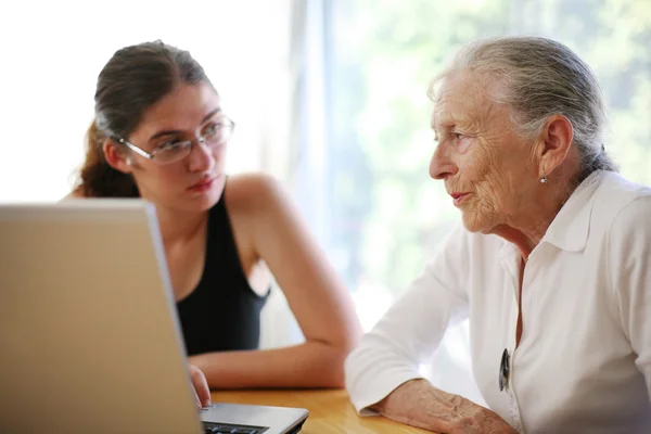 Grootmoeder en kleindochter met laptop. — Stockfoto