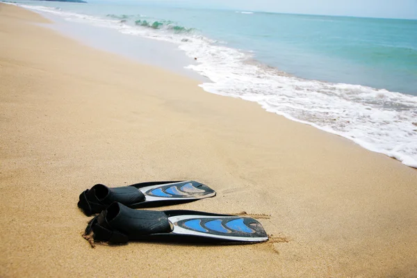Pair of swimfins on the sand at ocean water — Stock Photo, Image