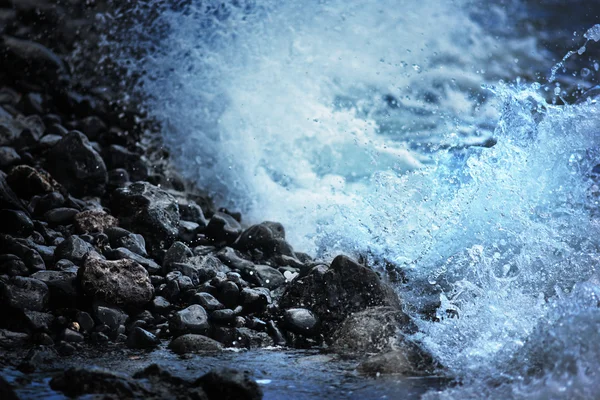 Ocean wave breaking on black stones of volcanic lava beach — Stock Photo, Image