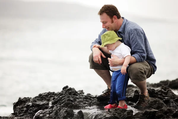 Dad with little son walking outdoors at ocean