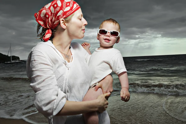 Mother and son at the ocean at sunset — Stock Photo, Image