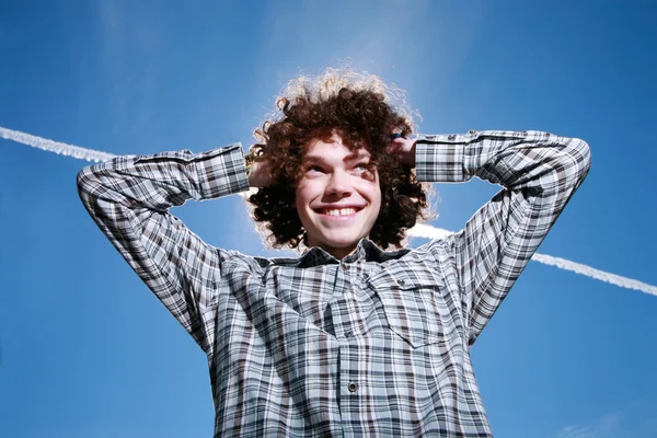 Šťastný mladý muž s kudrnatými vlasy — Stock fotografie