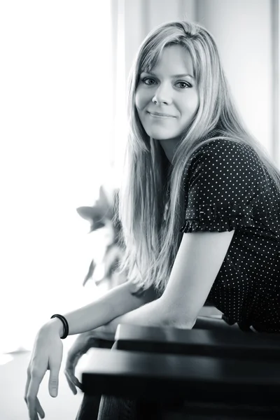 Beautiful young woman sitting in chair — Stock Photo, Image