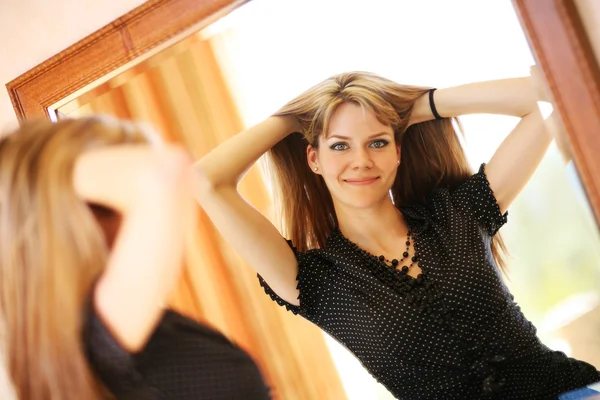 Piękna młoda kobieta patrząca w lustro — Zdjęcie stockowe