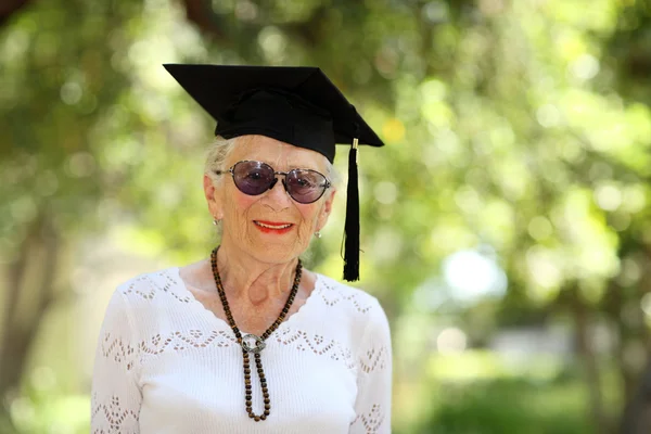 Feliz mujer mayor en gorra de graduado — Foto de Stock