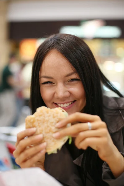 Vacker flicka äter hamburgare — Stockfoto