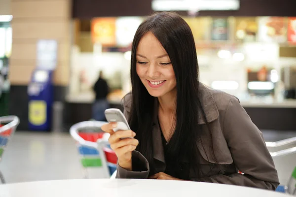 Junge Frau schaut aufs Handy. — Stockfoto