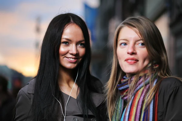 Zwei schöne Mädchen auf einer Straße bei Sonnenuntergang. — Stockfoto