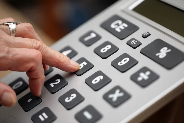 Starší žena prsty kláves na kalkulačce — Stock fotografie