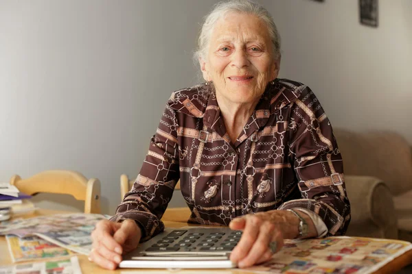 Donna anziana con grande calcolatrice — Foto Stock