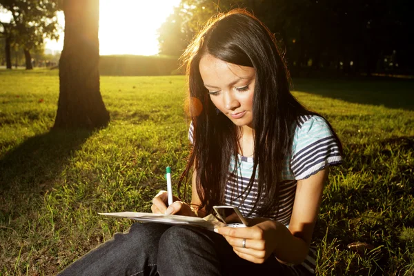 Mooie jonge vrouwelijke student studeert buitenshuis — Stockfoto