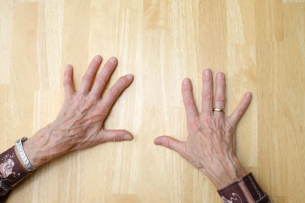 Old hands on clean table — Stock Photo, Image