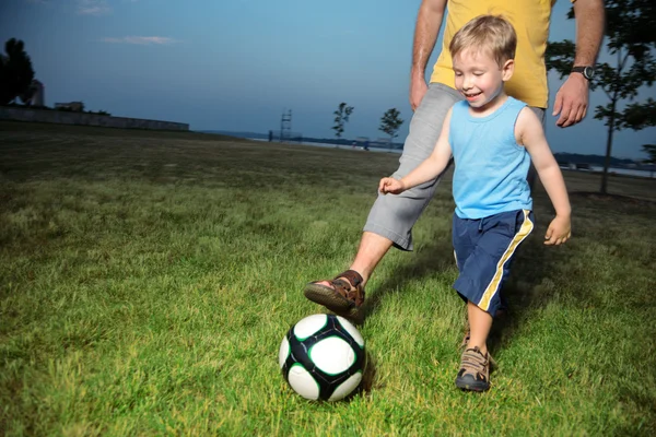 Ragazzo che gioca a calcio con suo padre all'aperto — Foto Stock