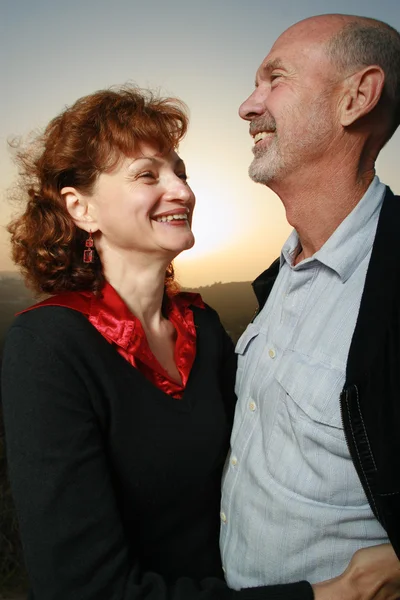 Mature couple embracing at sunset. — Stock Photo, Image