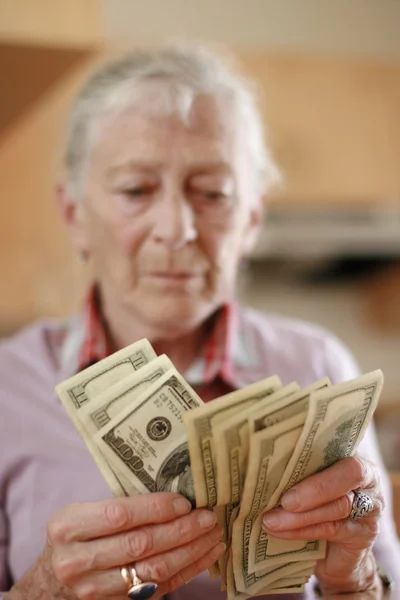Mujer mayor contando dinero de ahorros —  Fotos de Stock