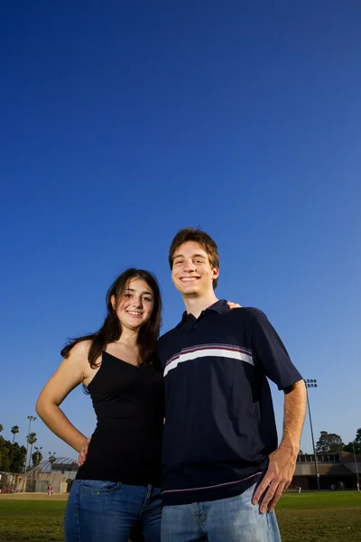 Couple embracing on a playing field. — Stock Photo, Image