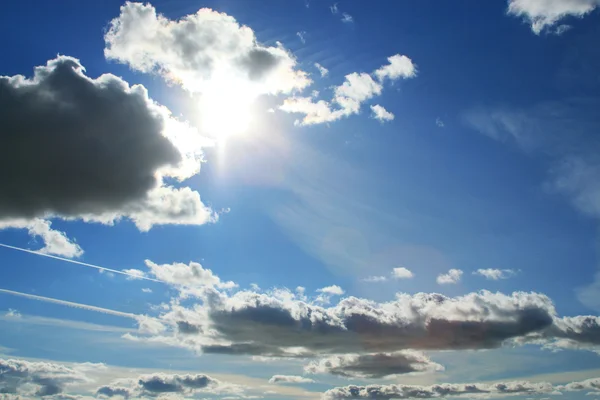 Wolken en zon op blauwe hemel — Stockfoto