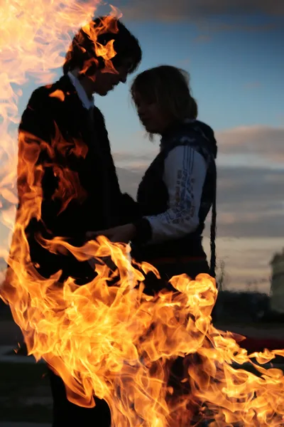 Genç çift siluet ateşle — Stok fotoğraf