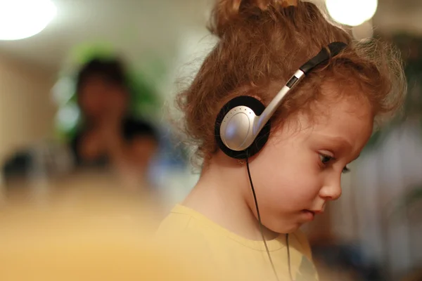 Little girl listening fairytale in headphones — Stock Photo, Image