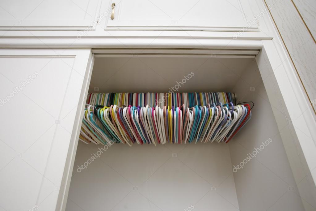 Colorful hangers in empty white closet