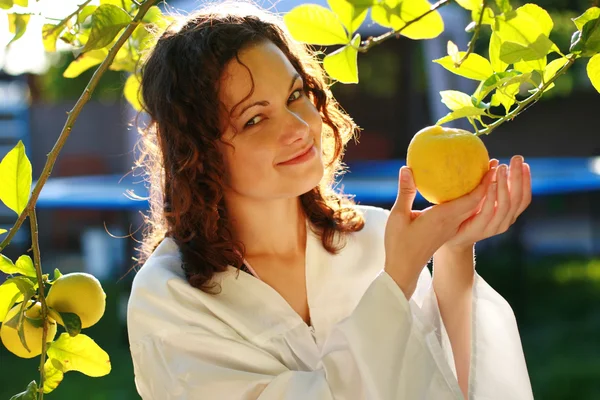 Young woman picking up a fresh lemon — Stock Photo, Image