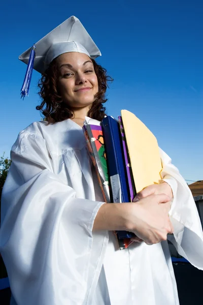 Étudiant diplômé tenant une grande pile de manuels scolaires — Photo