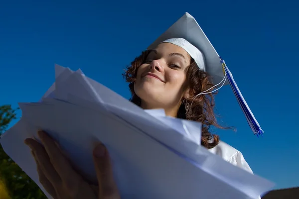 Young graduate woman with heap of papers. — Stock Photo, Image