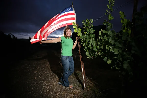 Jovem mulher de pé com bandeira americana — Fotografia de Stock