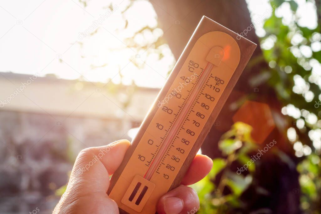 hand holding thermometer with high temperatures in the hot su