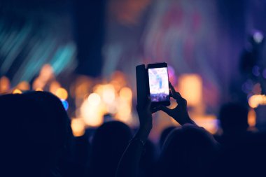 Konserde elinde modern akıllı telefon tutan biri..