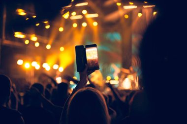 Konserde elinde modern akıllı telefon tutan biri..