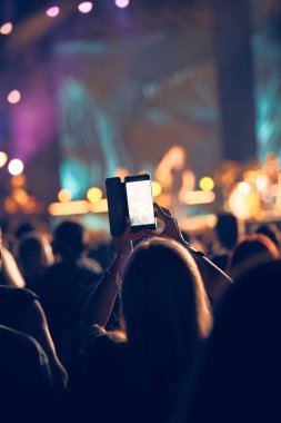 Konserde elinde modern akıllı telefon tutan biri..