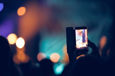 Konserde elinde modern akıllı telefon tutan biri..