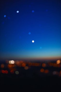 Out of focus landscape with bokeh star and distant city streetlights.