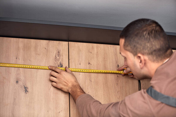 Мастер по изготовлению кухонных шкафов в квартире.